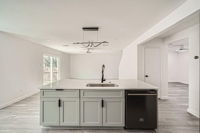 kitchen with a kitchen island with sink, dishwasher, sink, and light wood-type flooring