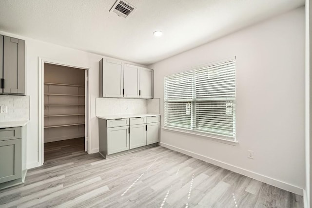 kitchen featuring decorative backsplash and light hardwood / wood-style flooring