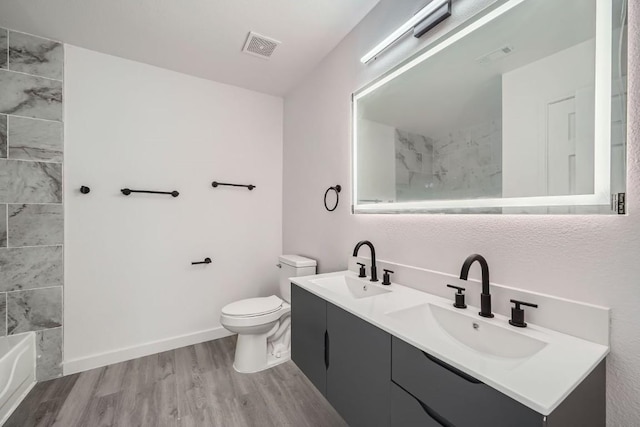 bathroom with vanity, toilet, and hardwood / wood-style floors