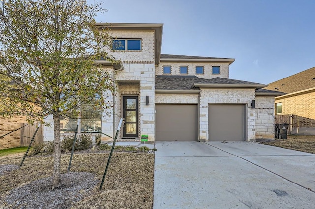155 Cyrus Milton Dr, Buda, TX 78610 - view of front of home featuring driveway, stone siding, roof with shingles, and an attached garage