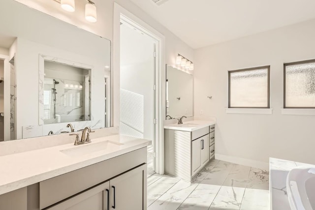 155 Cyrus Milton Dr, Buda, TX 78610 - bathroom featuring marble look tile flooring, two vanities, a bath, a shower, and baseboards