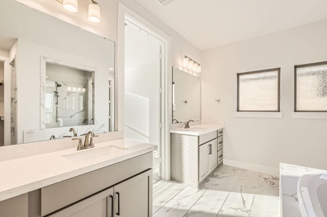 155 Cyrus Milton Dr, Buda, TX 78610 - bathroom featuring marble finish floors, two vanities, a garden tub, and a shower