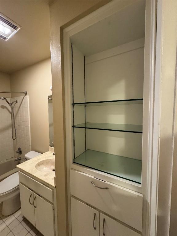 full bathroom featuring vanity, toilet, tiled shower / bath combo, and tile patterned flooring