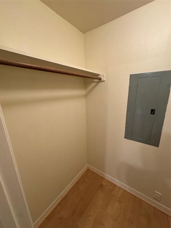 walk in closet with hardwood / wood-style flooring and electric panel