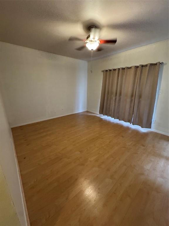 spare room with a textured ceiling, wood-type flooring, and ceiling fan