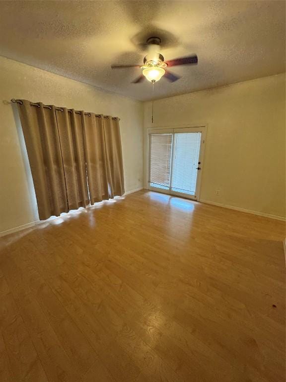 spare room with ceiling fan, hardwood / wood-style flooring, and a textured ceiling