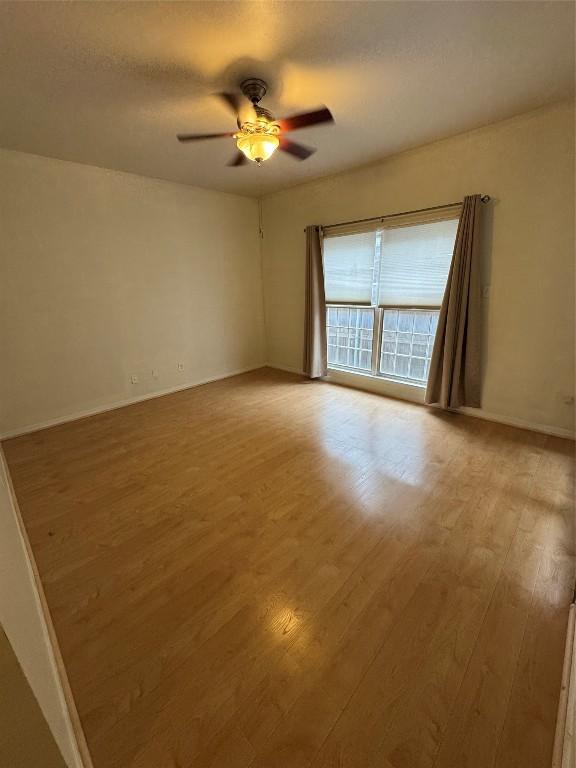 spare room with ceiling fan, a textured ceiling, and light wood-type flooring