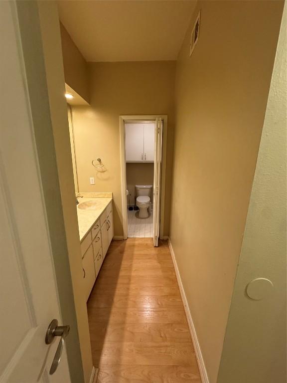 bathroom featuring hardwood / wood-style flooring, vanity, and toilet