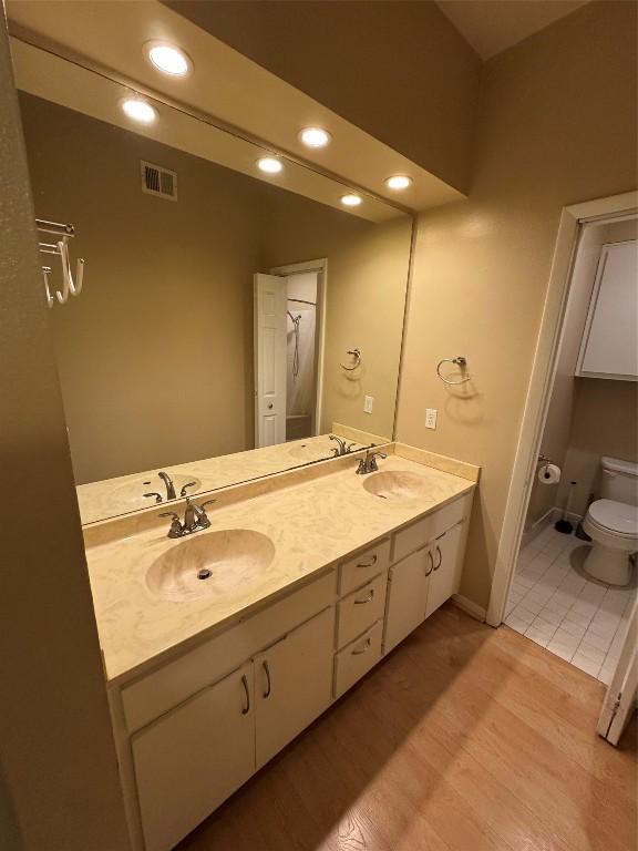 bathroom with vanity, toilet, and wood-type flooring