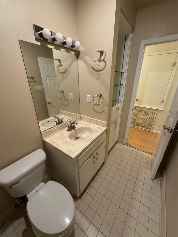 bathroom featuring vanity, tile patterned flooring, and toilet