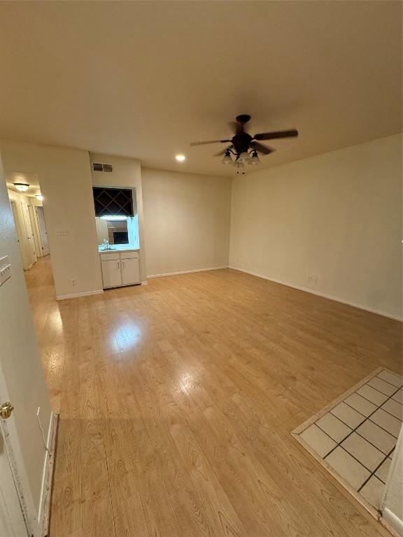 unfurnished living room with ceiling fan and light hardwood / wood-style flooring