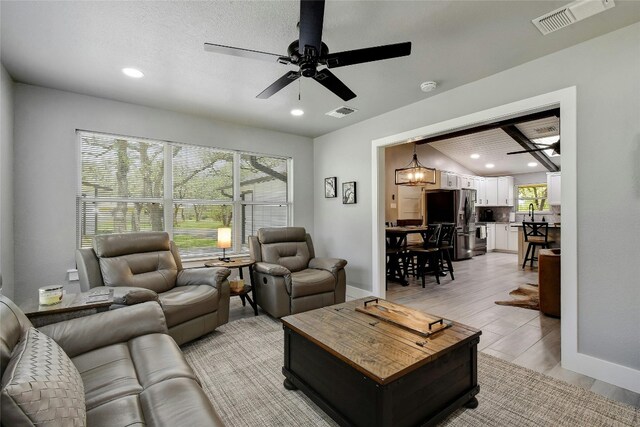 living room featuring sink, light hardwood / wood-style flooring, and ceiling fan