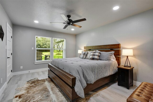 bedroom featuring ceiling fan, a textured ceiling, and light wood-type flooring