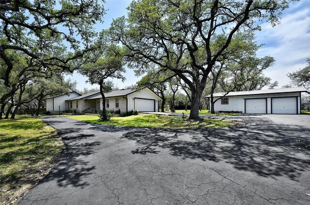 ranch-style home featuring a garage and a front lawn