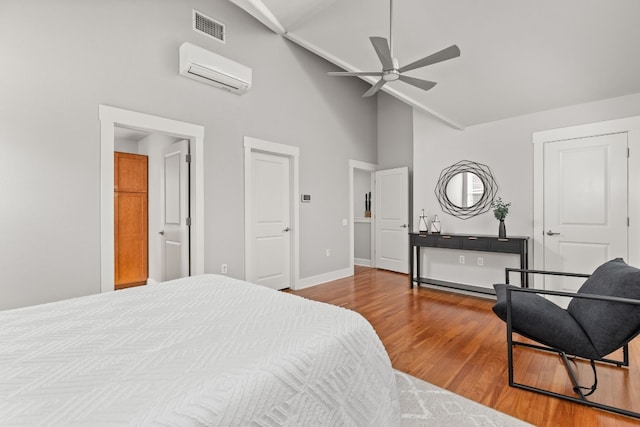 bedroom featuring wood-type flooring, an AC wall unit, and high vaulted ceiling