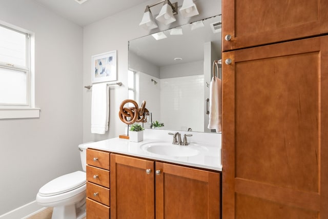 bathroom featuring vanity, a shower, and toilet