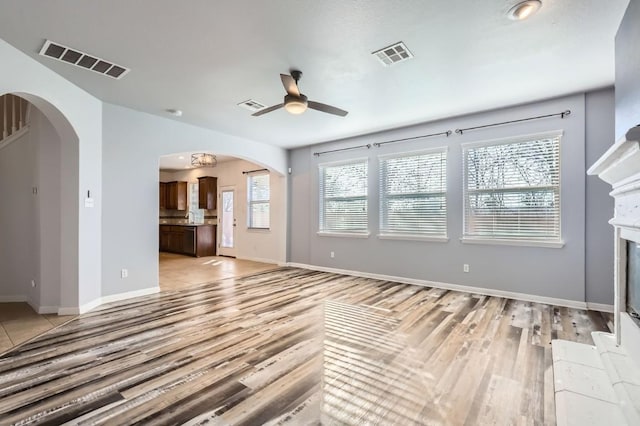 unfurnished living room featuring ceiling fan and light wood-type flooring