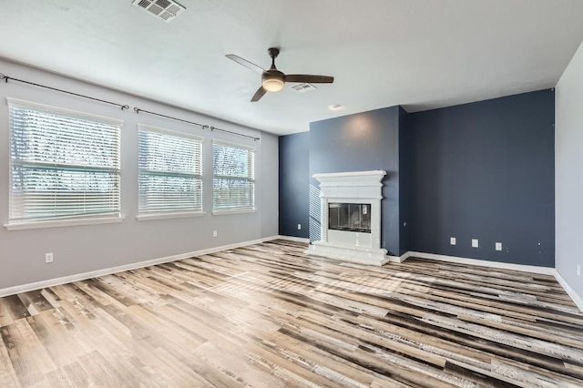 unfurnished living room featuring hardwood / wood-style flooring and ceiling fan