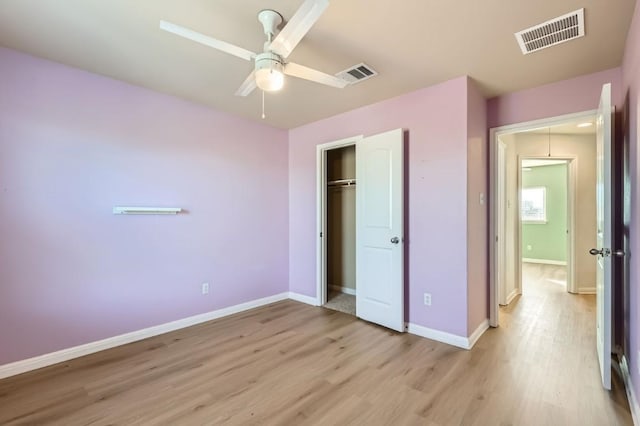 unfurnished bedroom featuring ceiling fan, light wood-type flooring, and a closet