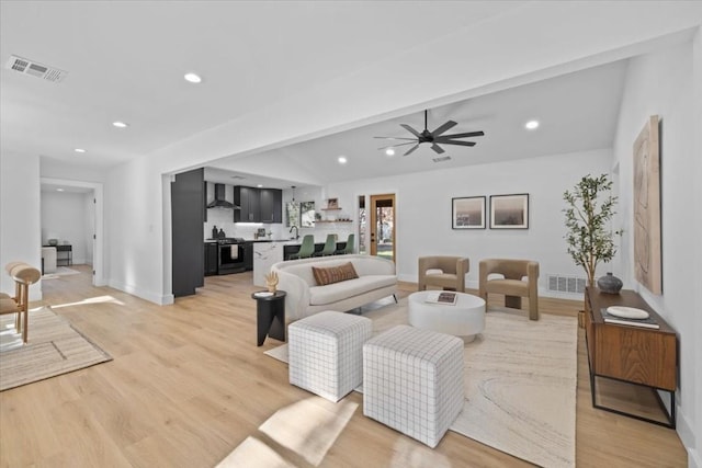 living room with lofted ceiling, light hardwood / wood-style floors, and ceiling fan