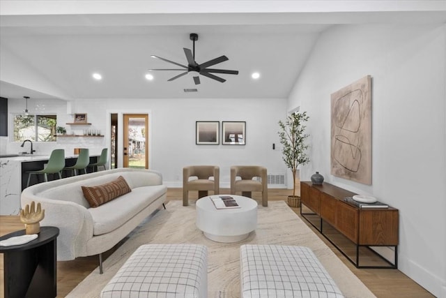 living room featuring vaulted ceiling, sink, ceiling fan, and light hardwood / wood-style floors