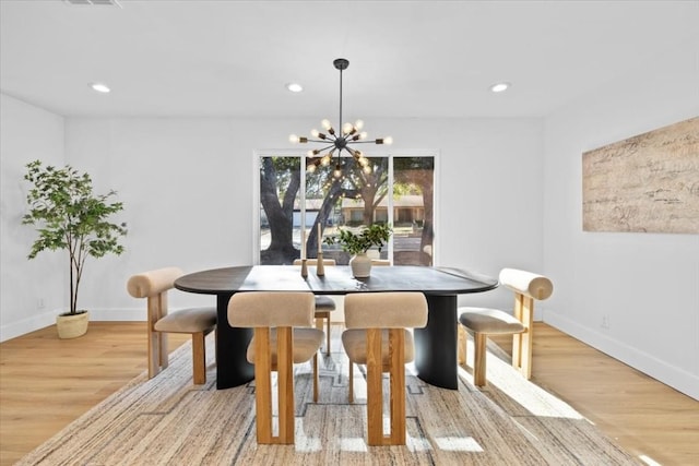 dining space with an inviting chandelier and light hardwood / wood-style floors