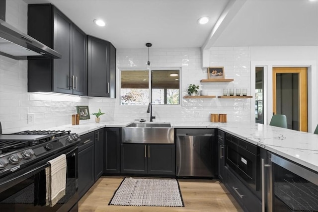 kitchen with black range with gas cooktop, sink, stainless steel dishwasher, beverage cooler, and wall chimney range hood