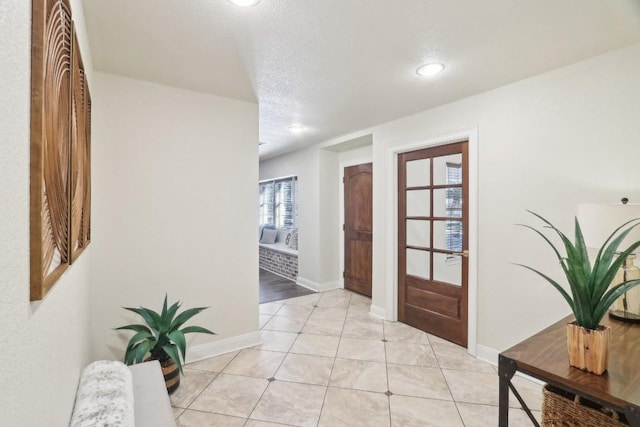 tiled entryway with a textured ceiling