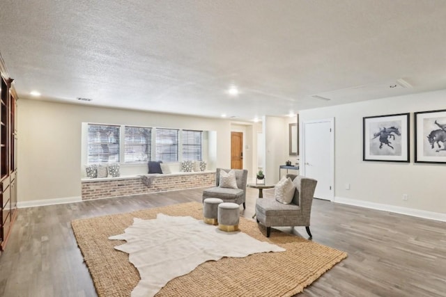 sitting room with wood-type flooring and a textured ceiling