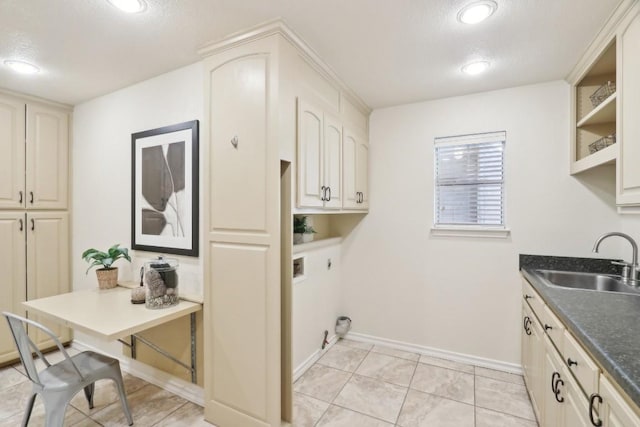 washroom featuring washer hookup, hookup for an electric dryer, a sink, baseboards, and cabinet space