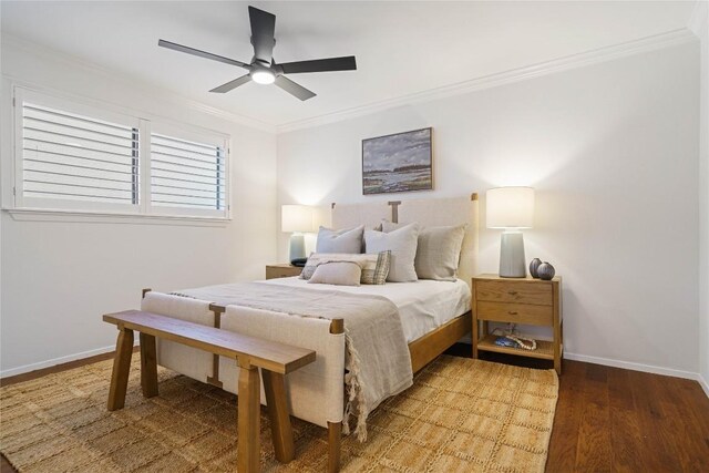 bedroom with ceiling fan, wood finished floors, baseboards, and ornamental molding