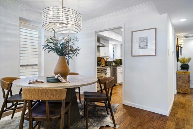 dining space with wood finished floors, baseboards, and crown molding