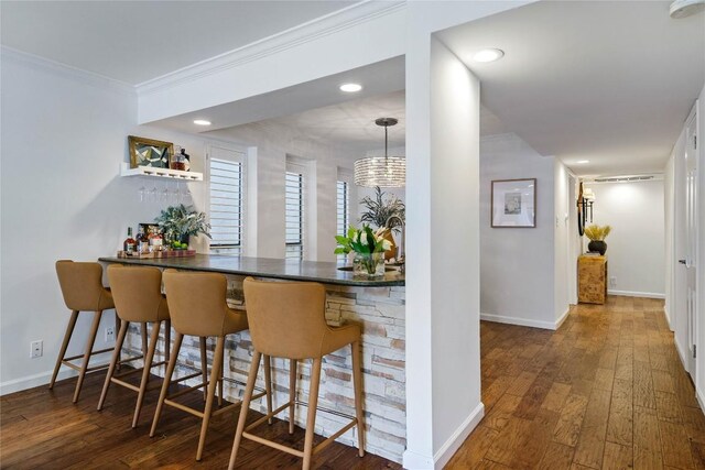 bar featuring recessed lighting, hardwood / wood-style flooring, baseboards, and ornamental molding