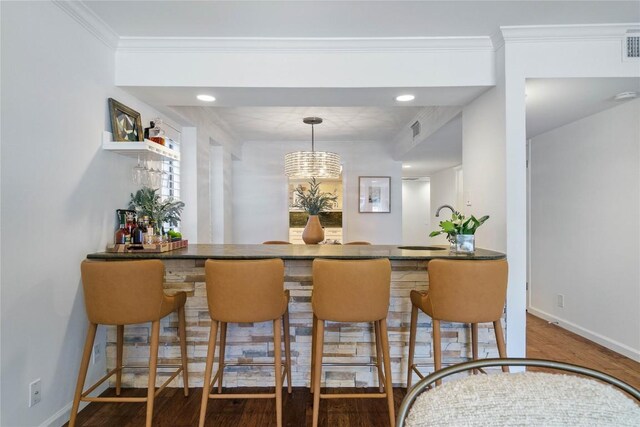 bar featuring baseboards, crown molding, wood finished floors, and visible vents