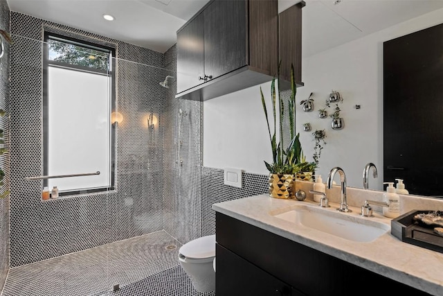 bathroom featuring vanity, toilet, and tiled shower