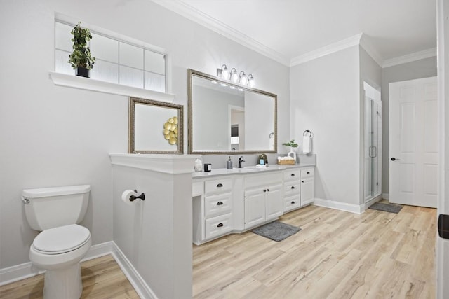 bathroom featuring hardwood / wood-style floors, ornamental molding, vanity, walk in shower, and toilet