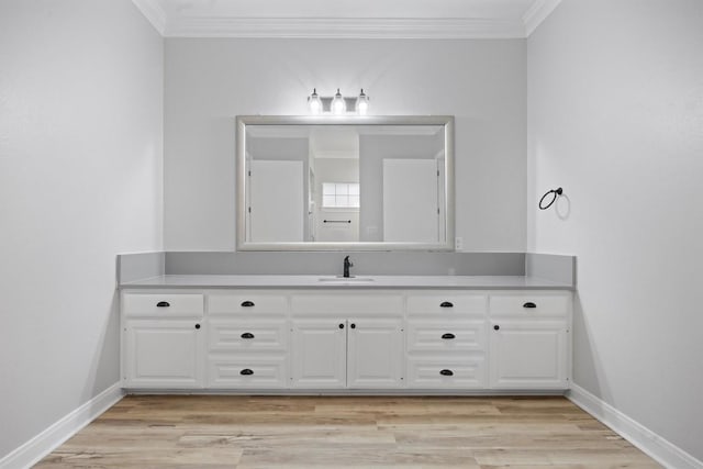 bathroom with ornamental molding, wood-type flooring, and vanity