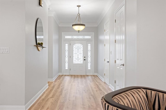 entryway featuring ornamental molding and light hardwood / wood-style flooring