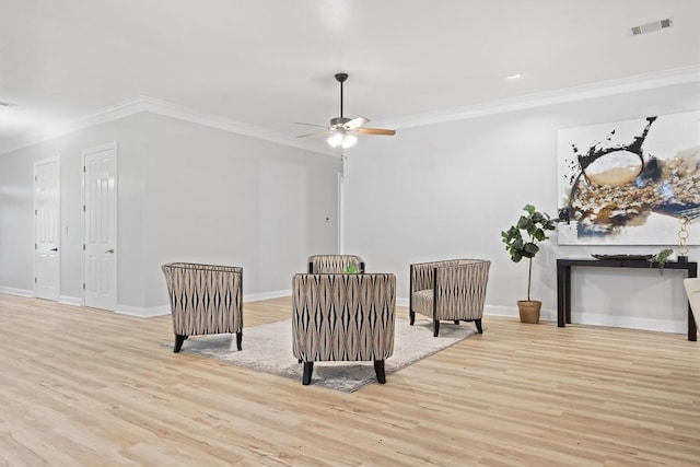 sitting room with crown molding, light hardwood / wood-style floors, and ceiling fan