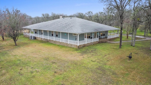 farmhouse with cooling unit, a front yard, and a porch