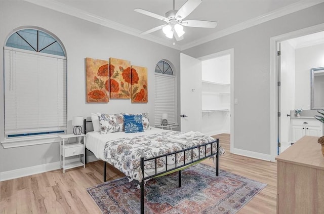 bedroom featuring ornamental molding, a spacious closet, ceiling fan, and light hardwood / wood-style flooring