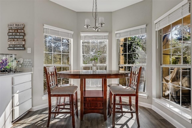 dining space with dark hardwood / wood-style flooring and a chandelier