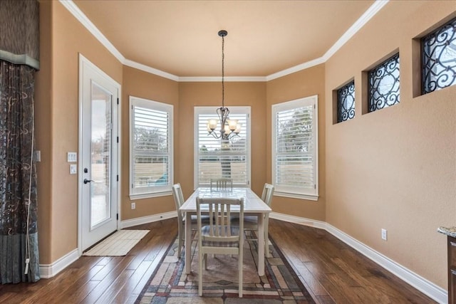 dining area with ornamental molding, dark wood-type flooring, and an inviting chandelier