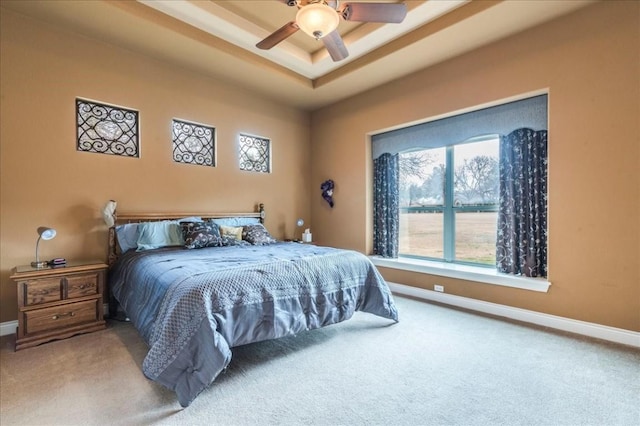 bedroom featuring a tray ceiling, ceiling fan, and carpet flooring