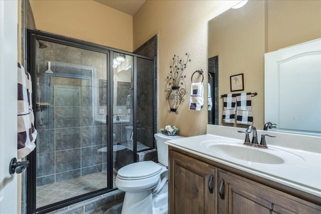 bathroom featuring vanity, toilet, and a shower with shower door