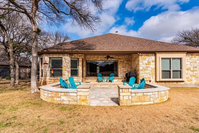 rear view of property with a yard, a fire pit, a patio, and ceiling fan