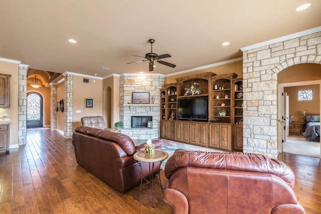 living room with crown molding, a fireplace, decorative columns, and hardwood / wood-style floors