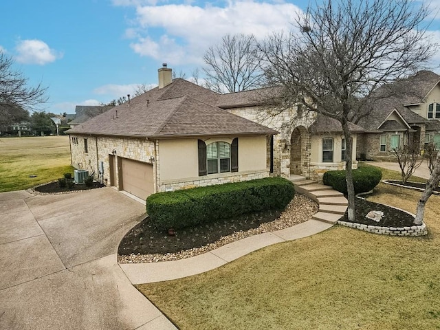 view of front of house with a garage, central air condition unit, and a front lawn