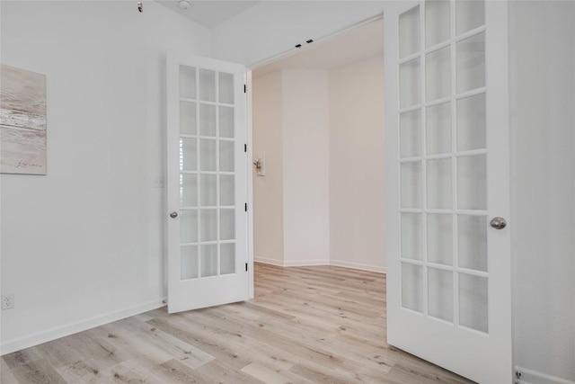 spare room with light hardwood / wood-style floors and french doors