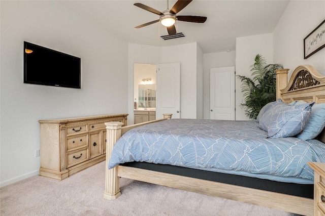 bedroom featuring ensuite bath, light colored carpet, and ceiling fan